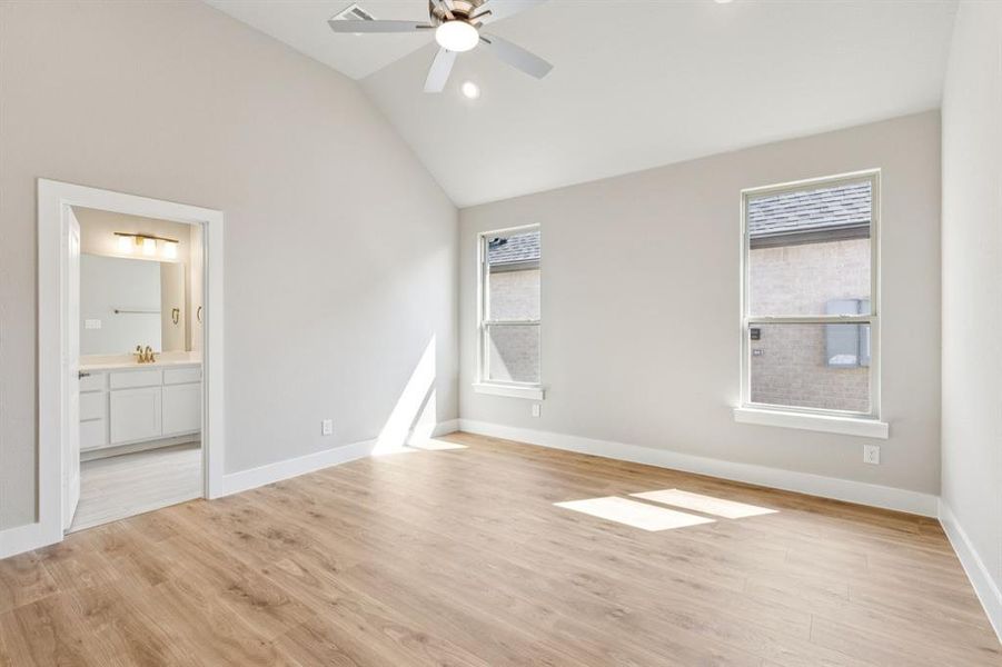 Unfurnished bedroom featuring lofted ceiling, light wood finished floors, multiple windows, recessed lighting, and ceiling fan