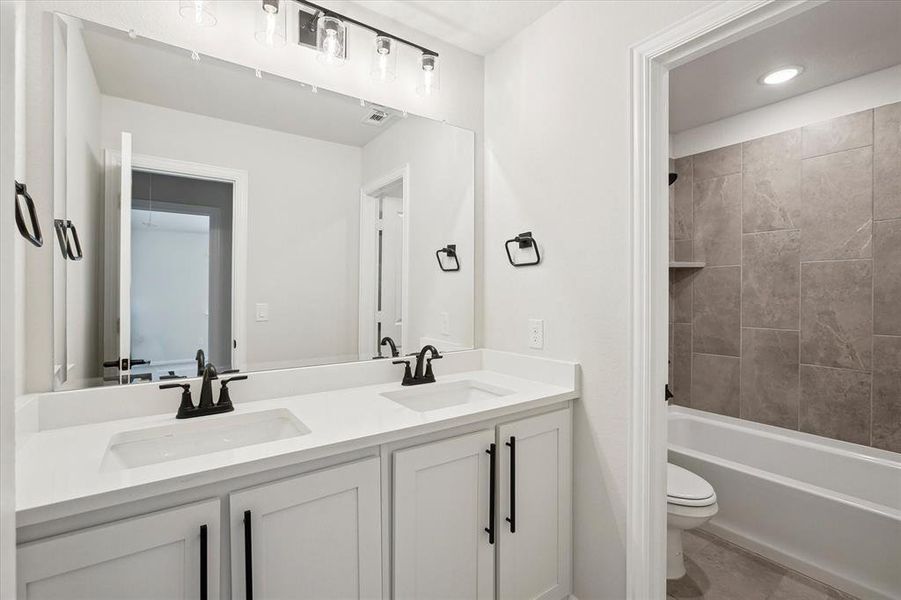 Full bath featuring double vanity, toilet, bathing tub / shower combination, tile patterned floors, and recessed lighting