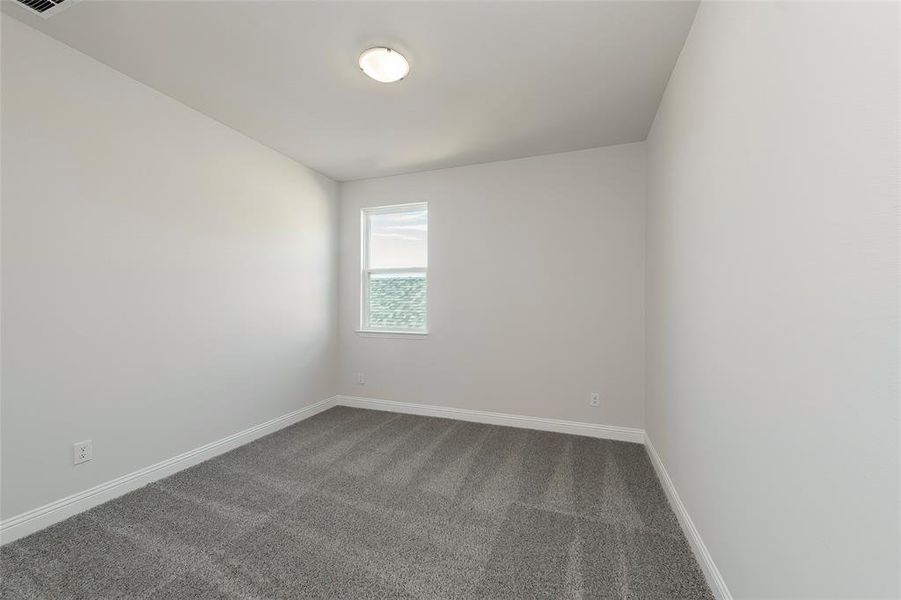 Empty room featuring dark carpet and baseboards Empty room featuring dark carpet and baseboards