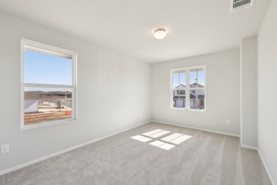 Image of a bedroom with grey walls, tan carpeting, windows and white trim