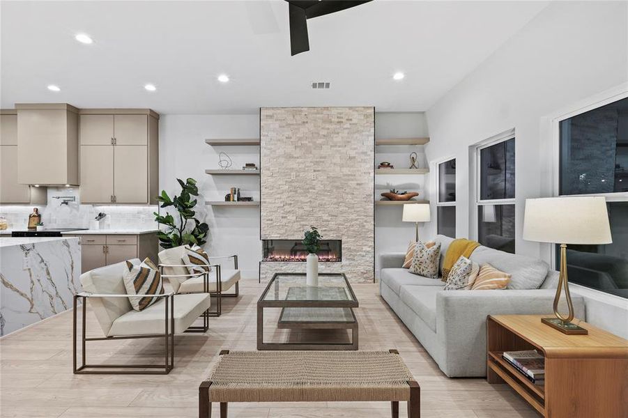 Living room featuring a stone fireplace and light hardwood / wood-style flooring