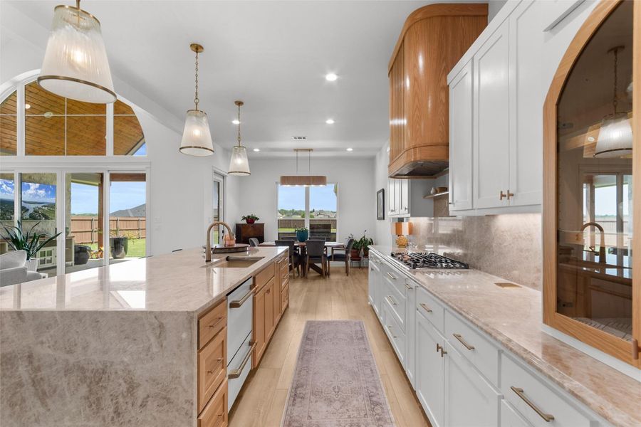 Kitchen has double ovens, GAS COOKTOP and custom white and brushed champagne café appliances, custom BUTLERS PANTRY and coffee bar. WHITE CABINETS with natural wood, granite and tile accents highlight the kitchen and pantry. Kitchen has double ovens, GAS COOKTOP and custom white and brushed champagne café appliances, custom BUTLERS PANTRY and coffee bar. WHITE CABINETS with natural wood, granite and tile accents highlight the kitchen and pantry.