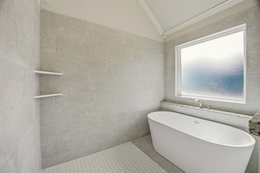 Bathroom with lofted ceiling, a soaking tub, tile walls, and crown molding Bathroom with lofted ceiling, a soaking tub, tile walls, and crown molding
