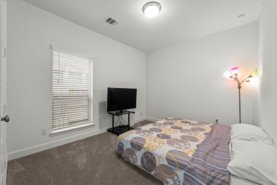 Another secondary bedroom offers lush carpeting, large wall closet, sunny window with 2” blinds, and ceiling light. It has hallway access to the third full bath shared with Bedroom 3.