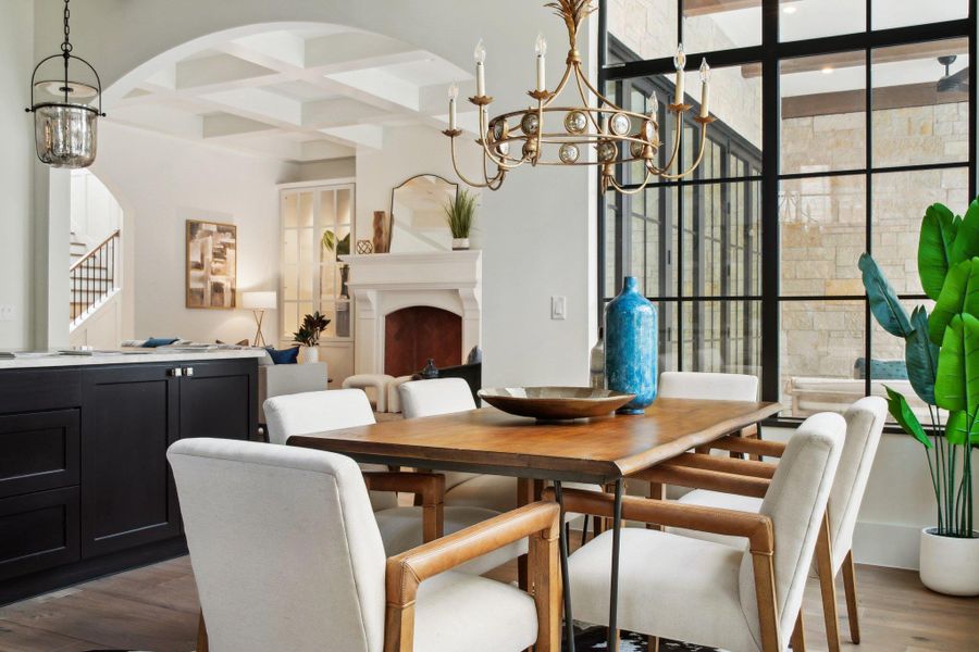 Dining space with beam ceiling, wood finished floors, arched walkways, a notable chandelier, and coffered ceiling