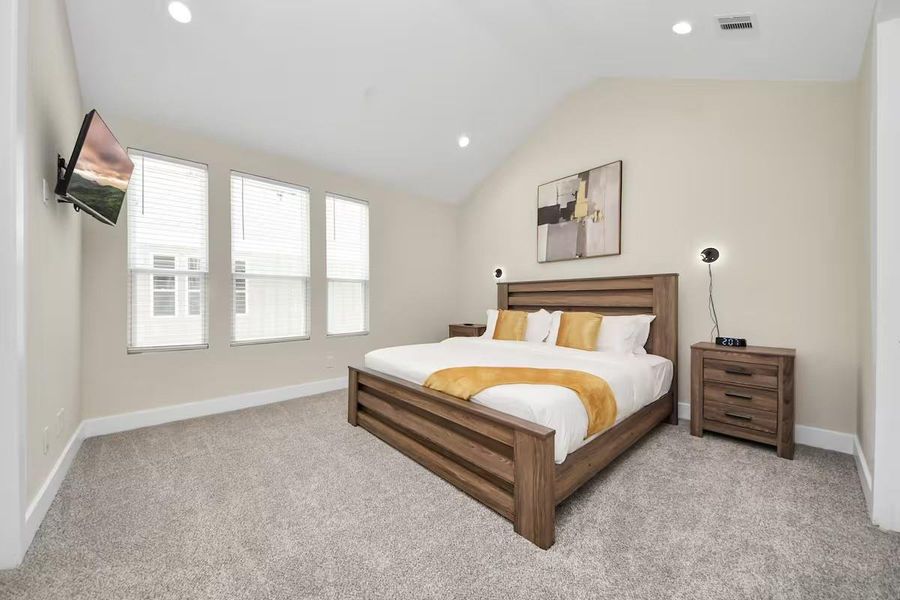 High ceilings and three windows give the primary bedroom an airy feel with plenty of natural light throughout the day.