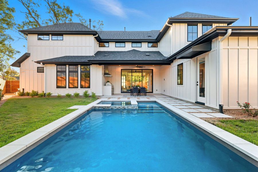 Back of house with a ceiling fan, a shingled roof, a patio area, a lawn, and board and batten siding Back of house with a ceiling fan, a shingled roof, a patio area, a lawn, and board and batten siding