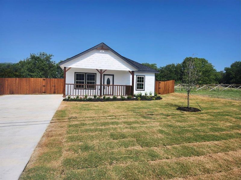 View of front of property featuring a porch and a front lawn