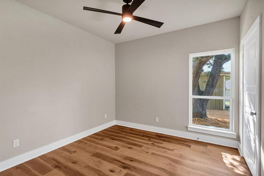 Spare room with wood finished floors and a ceiling fan Spare room with wood finished floors and a ceiling fan