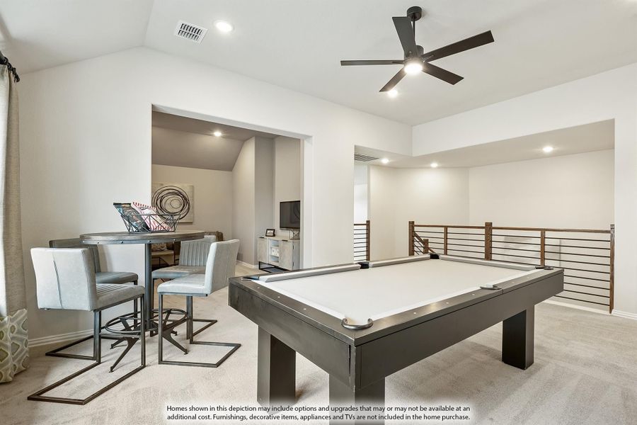 Game room with pool table, bar-height seating, ceiling fan, and open railing staircase on carpeted upper floor