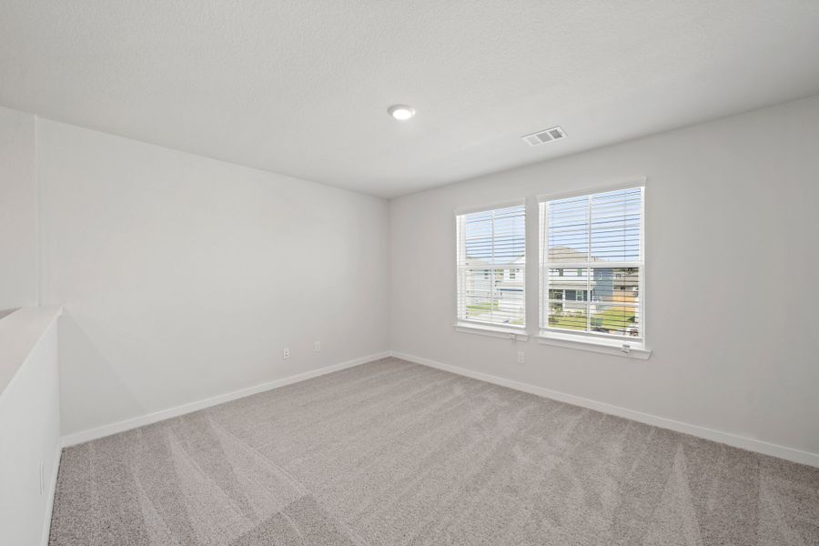 A room with windows and a carpet.