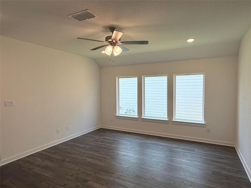 Spare room featuring dark wood-type flooring and a ceiling fan Spare room featuring dark wood-type flooring and a ceiling fan