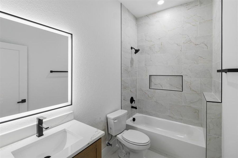 Full bath featuring vanity, a textured wall, and washtub / shower combination
