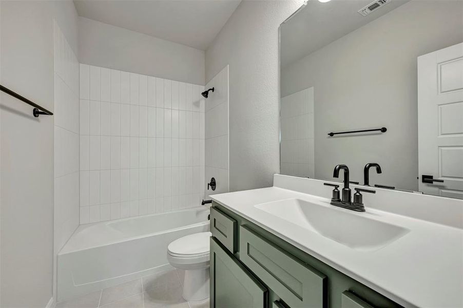 Bathroom with vanity, washtub / shower combination, and light tile patterned flooring Bathroom with vanity, washtub / shower combination, and light tile patterned flooring