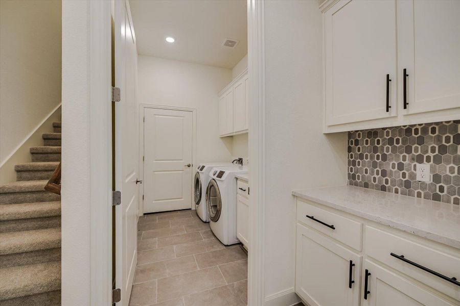 Washroom with cabinet space, washing machine and clothes dryer, light tile patterned floors, and recessed lighting Washroom with cabinet space, washing machine and clothes dryer, light tile patterned floors, and recessed lighting