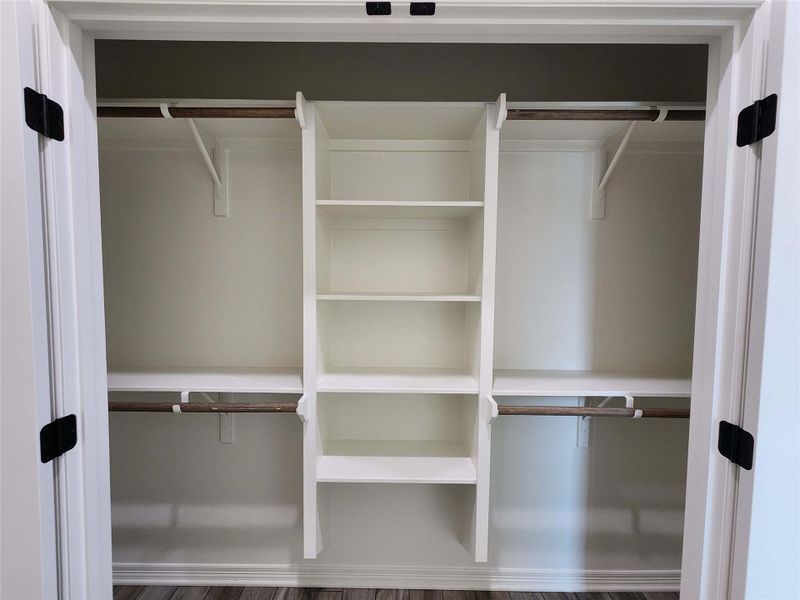 Custom closet system featuring central shelving and dual hanging rods