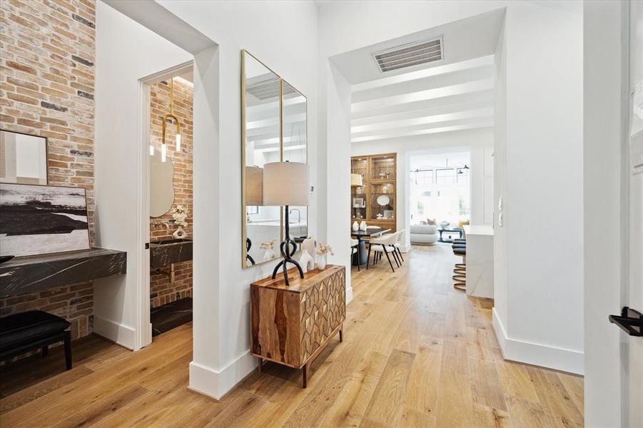 From the foyer, you'll notice the soaring 12-foot ceilings with custom beams and oversized aluminum windows. Nestled near the entry are the mudroom, powder room, and access to the garage.