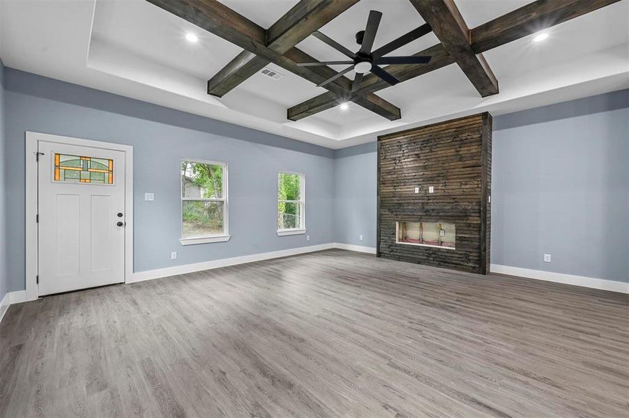 Unfurnished living room with coffered ceiling, hardwood / wood-style floors, ceiling fan, and a large fireplace