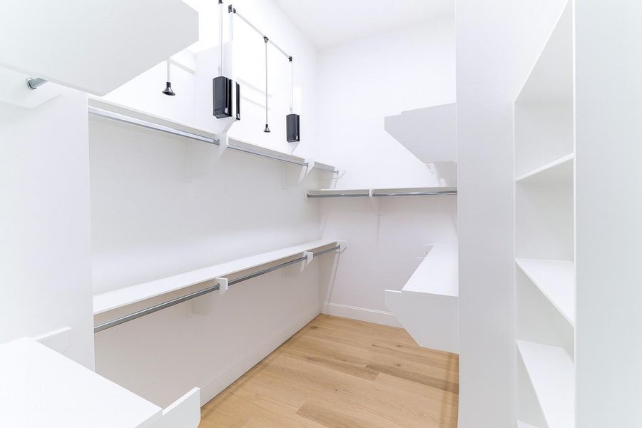 Huge closet in primary bedroom with extra shelving and pull-down racks for extra storage of seasonal clothing!