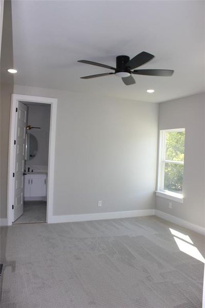 Carpeted spare room featuring ceiling fan