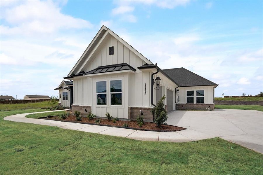 View of front of property featuring a garage and a front yard