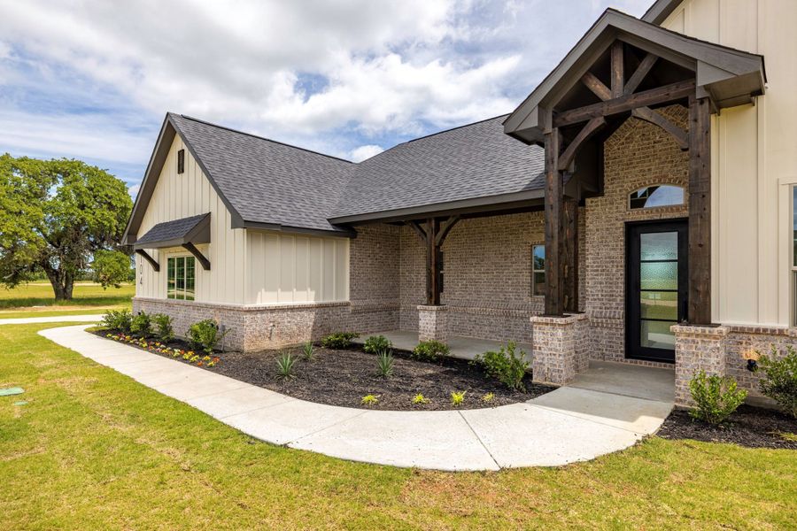 Front exterior of a new home in Prairie Winds Estates, Poolville, TX, highlighting curb appeal (Image 2). Front exterior of a new home in Prairie Winds Estates, Poolville, TX, highlighting curb appeal (Image 2).