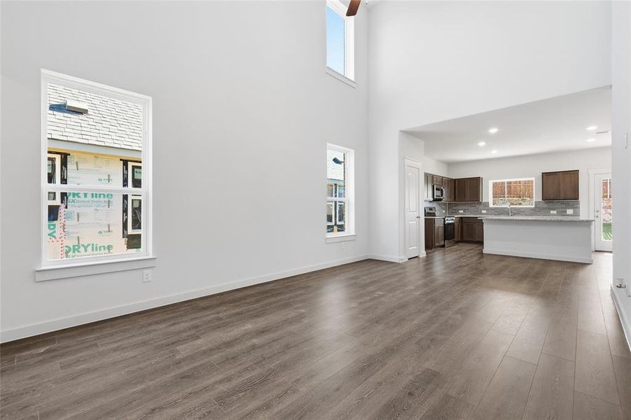 Expansive living area featuring soaring ceilings and wood-finish flooring