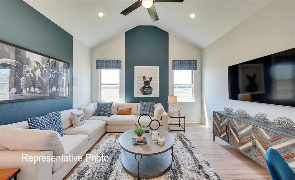 Vaulted ceilings in this living space featuring recessed lighting and a ceiling fan