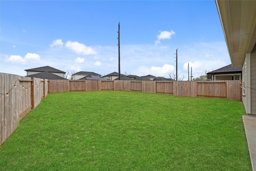 Expansive fenced backyard with a lush lawn, offering plenty of space for outdoor activities and relaxation. Expansive fenced backyard with a lush lawn, offering plenty of space for outdoor activities and relaxation.