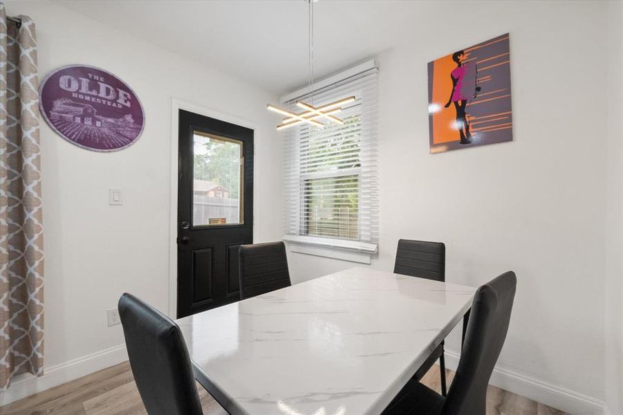 Dining space featuring light wood-style floors and a chandelier Dining space featuring light wood-style floors and a chandelier