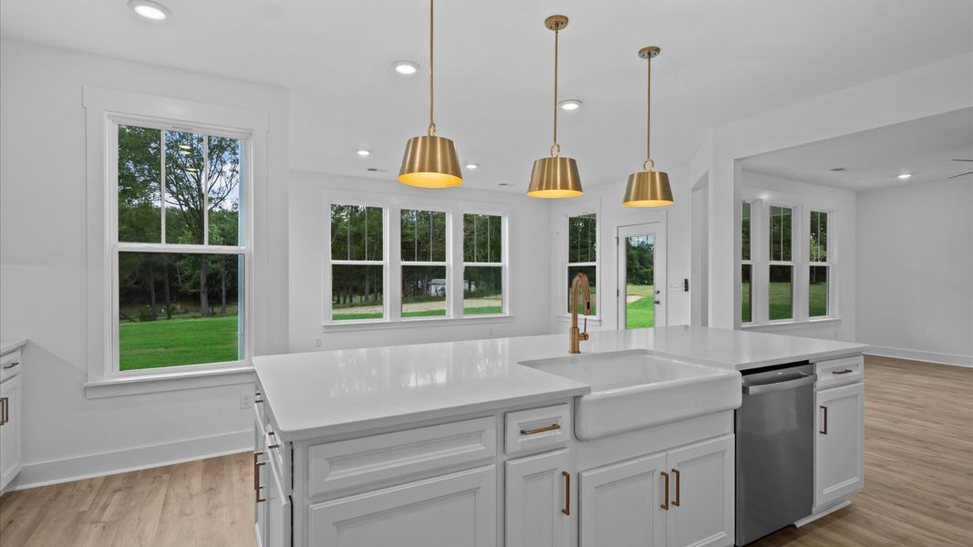 Highly skilled craftsmanship shines in this modern kitchen with pendant lighting and a central island focal point