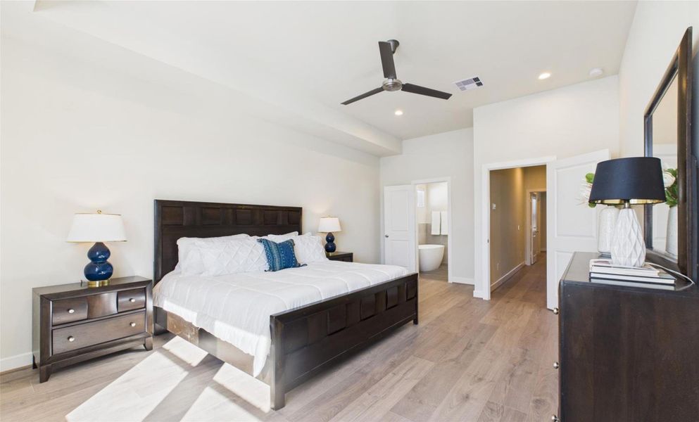 Enter into the large primary bedroom with high ceilings