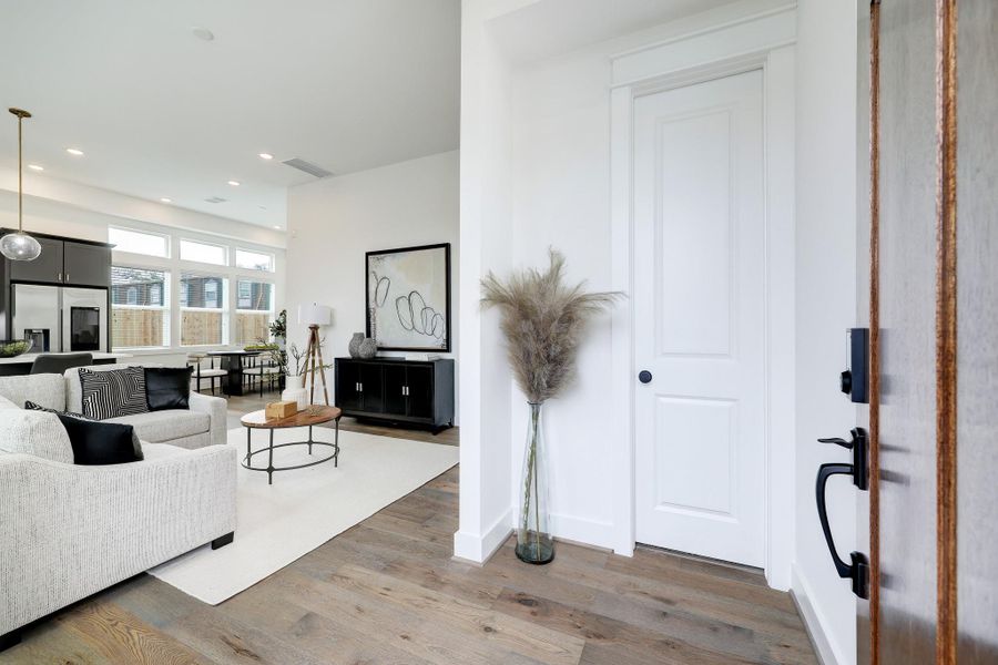 Welcome to an inviting foyer that opens into a spacious, light-filled living area, adorned with chic decor and warm wood flooring. Welcome to an inviting foyer that opens into a spacious, light-filled living area, adorned with chic decor and warm wood flooring.