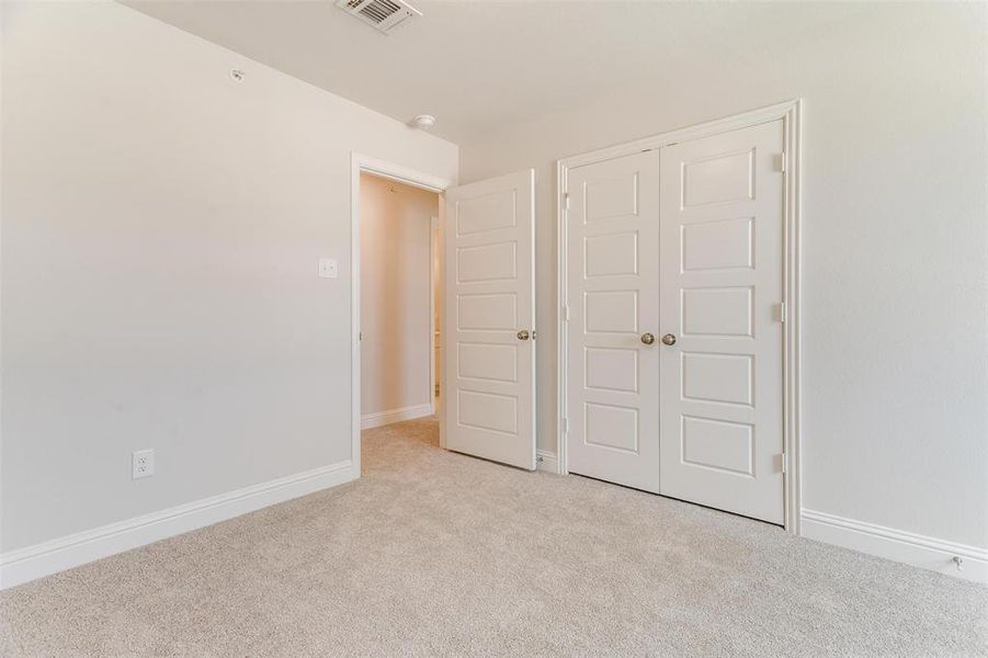 Unfurnished bedroom featuring light colored carpet and a closet