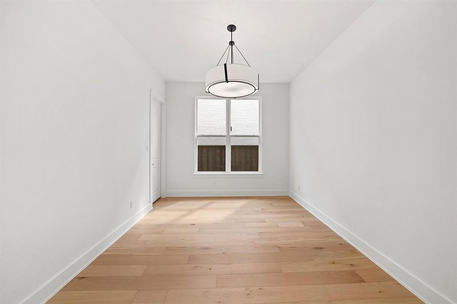 Unfurnished dining area with light wood-style floors and baseboards Unfurnished dining area with light wood-style floors and baseboards