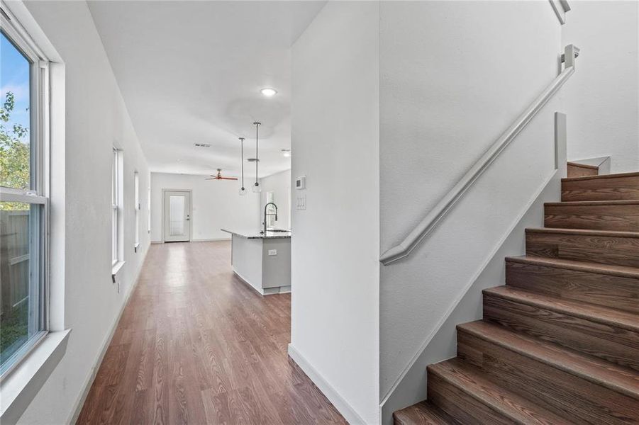 Stairs featuring wood finished floors and a ceiling fan
