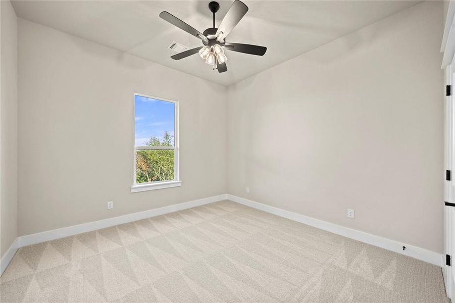 Unfurnished room with light colored carpet and a ceiling fan