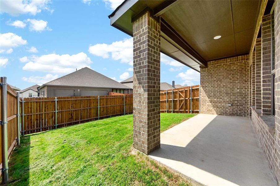 Spacious covered patio featuring brick columns and exterior wall, recessed lighting, and a concrete surface