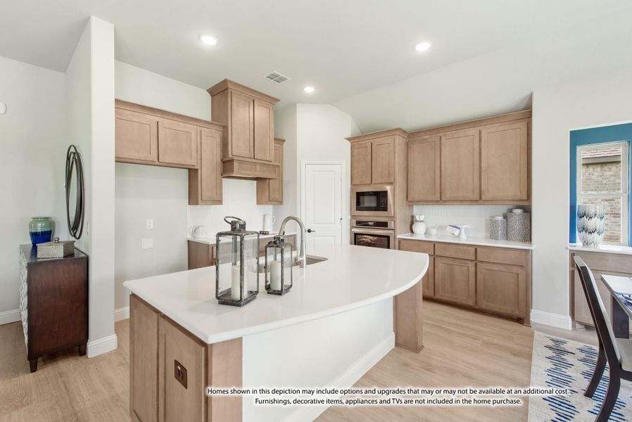 Kitchen with light wood cabinets, white countertop island, stainless steel appliances, and hardwood floors Kitchen with light wood cabinets, white countertop island, stainless steel appliances, and hardwood floors