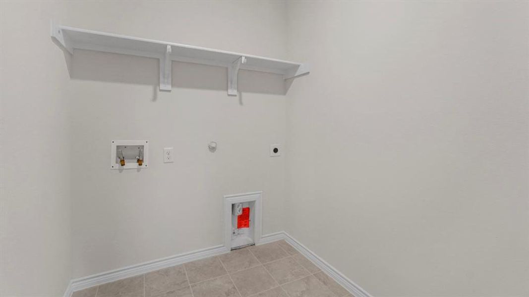 Laundry room featuring gas dryer hookup, hookup for a washing machine, hookup for an electric dryer, and light tile patterned floors Laundry room featuring gas dryer hookup, hookup for a washing machine, hookup for an electric dryer, and light tile patterned floors