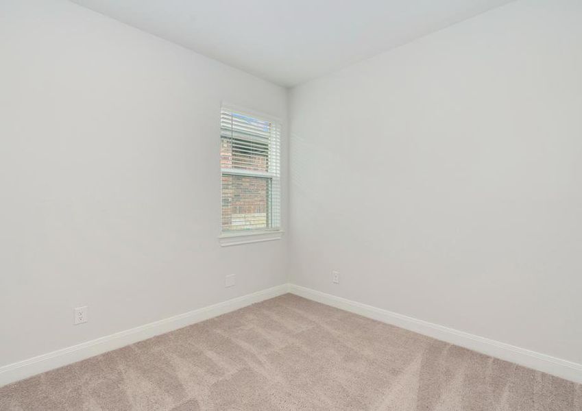 Secondary bedroom with a single window and tan carpet.