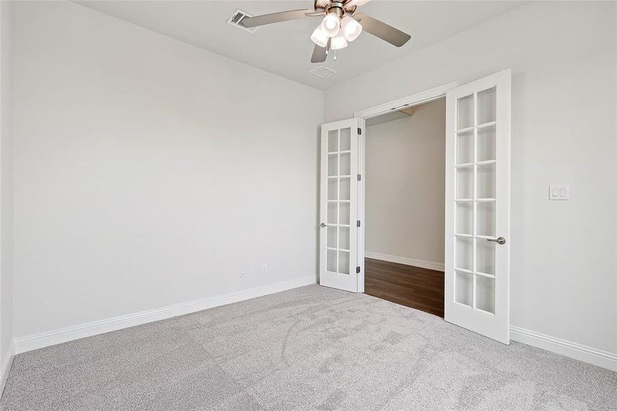 Unfurnished bedroom with carpet flooring, french doors, and ceiling fan