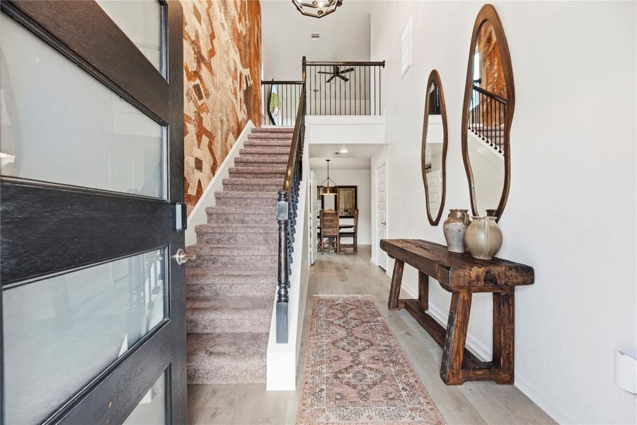 Beautiful front entry with a high ceiling, laminate flooring, neutral paint and striking accent wall. Beautiful front entry with a high ceiling, laminate flooring, neutral paint and striking accent wall.