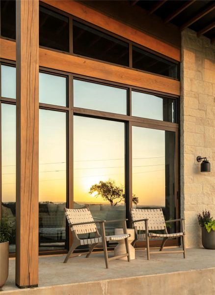 A striking facade combines wood and stone with generous windows, framing a picturesque sunset. A striking facade combines wood and stone with generous windows, framing a picturesque sunset.