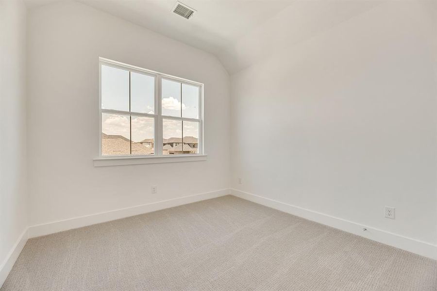Unfurnished room featuring light carpet and vaulted ceiling Unfurnished room featuring light carpet and vaulted ceiling