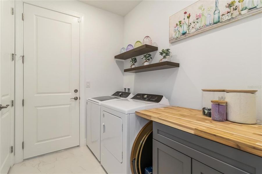 Laundry Room with upgraded Washer and Dryer plus cabinets and shelving