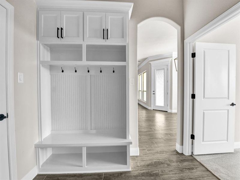 Mudroom with arched walkways, baseboards, and wood finished floors Mudroom with arched walkways, baseboards, and wood finished floors