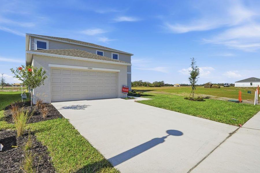 Front exterior of a new home in Firethorn, Parrish, FL, highlighting curb appeal (Image 25).