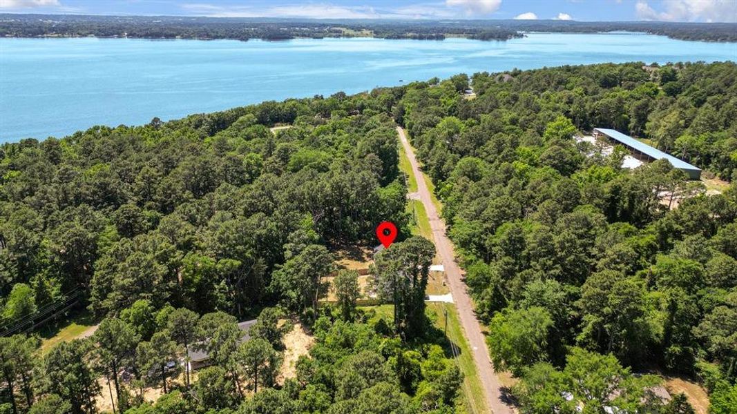 Drone / aerial view of a heavily wooded area and a nearby body of water Drone / aerial view of a heavily wooded area and a nearby body of water