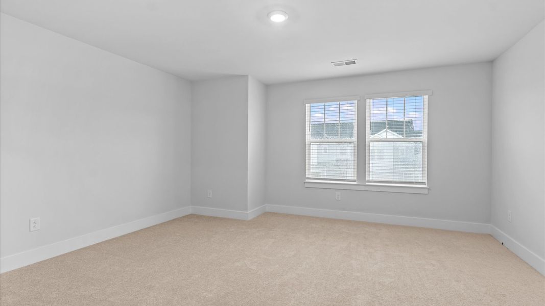 Memorable space with walk-in closet, soft carpeting, and natural light from large windows at Silo Ridge by DRB Homes